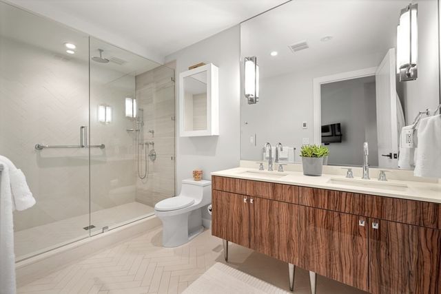 a bathroom with a double vanity sink toilet and shower