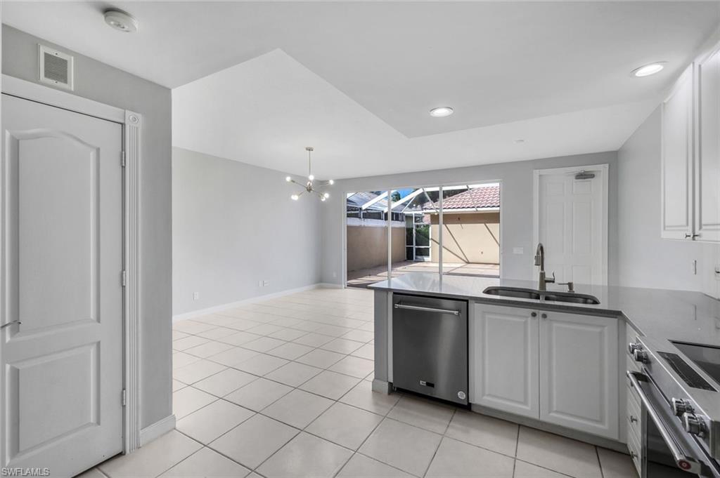 3462 Bravada Way Naples, FL 34119 - Photo 12 of 35 a kitchen with stainless steel appliances granite countertop a sink and cabinets