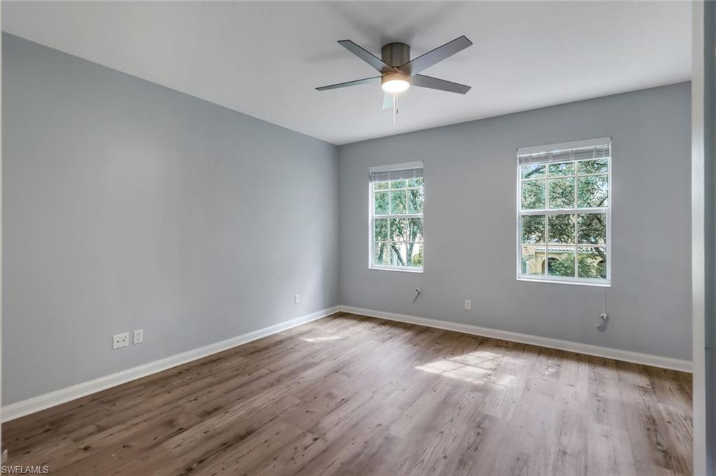 3462 Bravada Way Naples, FL 34119 - Photo 14 of 35 an empty room with wooden floor and windows