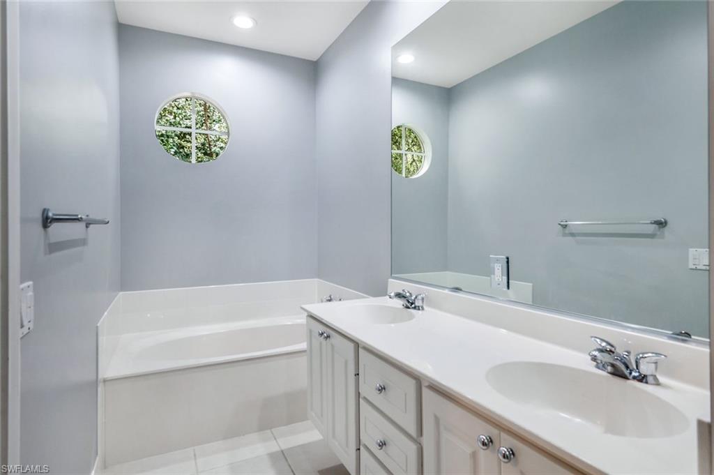 3462 Bravada Way Naples, FL 34119 - Photo 17 of 35 a bathroom with a sink a vanity and a bathtub