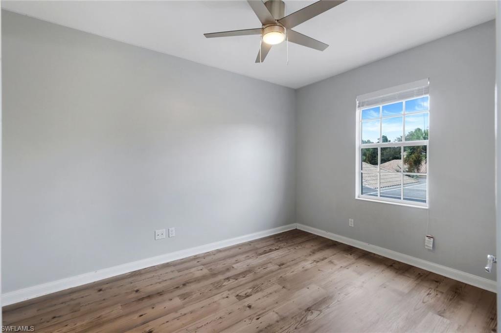 3462 Bravada Way Naples, FL 34119 - Photo 19 of 35 an empty room with wooden floor and windows
