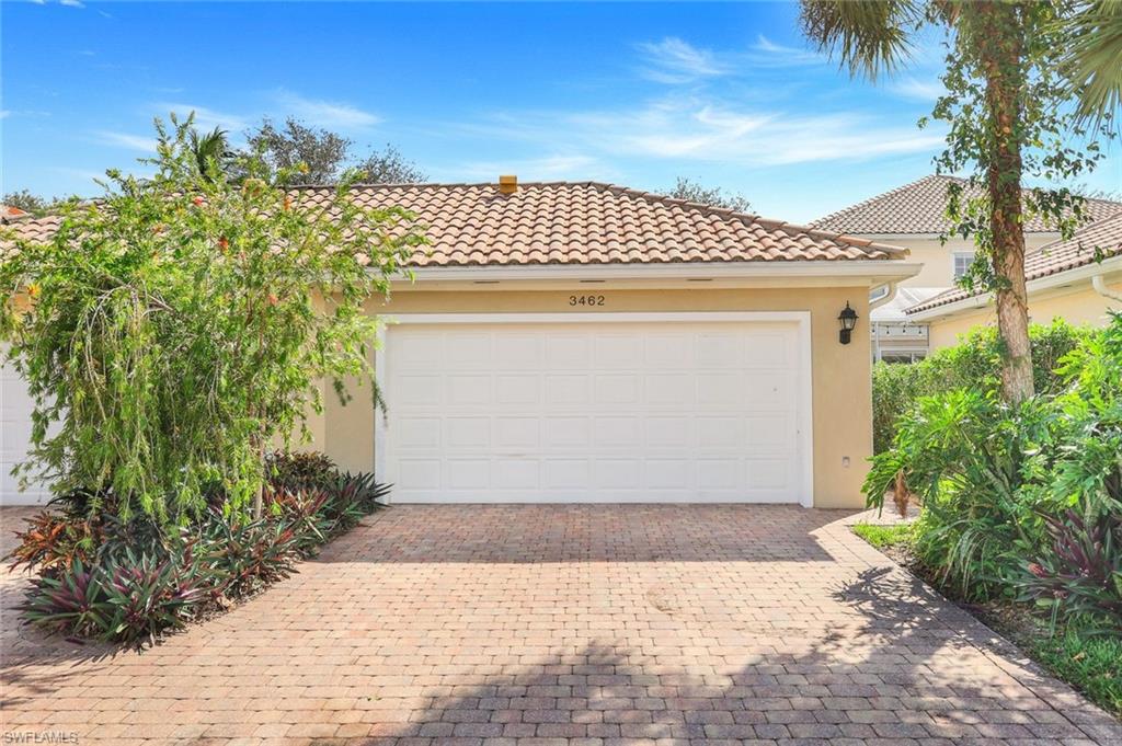 3462 Bravada Way Naples, FL 34119 - Photo 26 of 35 a front view of a house with a yard and garage