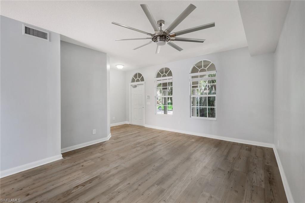 3462 Bravada Way Naples, FL 34119 - Photo 3 of 35 wooden floor in an empty room with a window