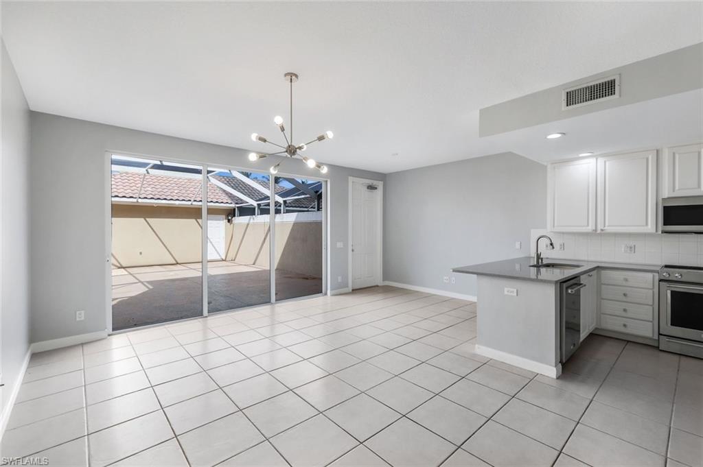 3462 Bravada Way Naples, FL 34119 - Photo 6 of 35 a large kitchen with a stove a sink dishwasher and a refrigerator
