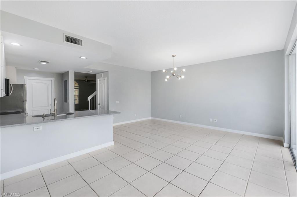 3462 Bravada Way Naples, FL 34119 - Photo 8 of 35 an empty room with kitchen view and natural light