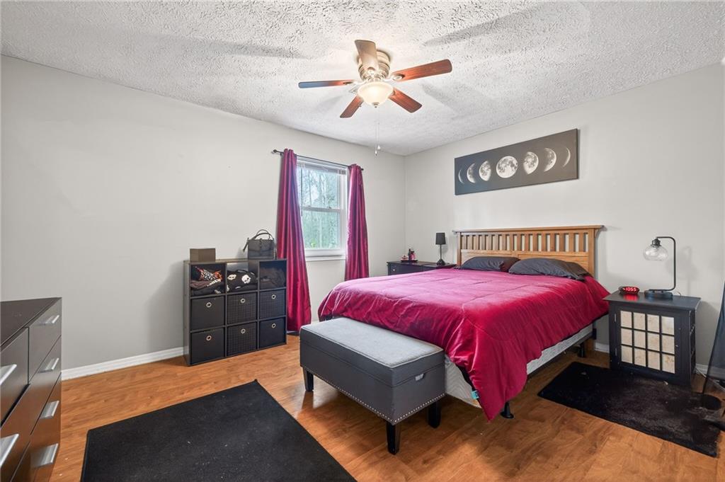 1572 Kings Ridge Drive Northwest Norcross, GA 30093 - Photo 14 of 20 a spacious bedroom with a bed and a chandelier