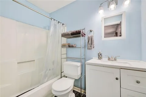 a bathroom with a toilet sink vanity and mirror
