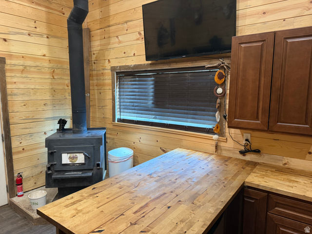 785 Hardscrabble Road Morgan, UT 84050 - Photo 12 of 16 Wood-paneled interior featuring a black wood-burning stove with metal flue and a built-in window with dark blinds