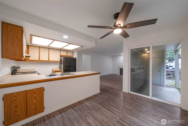 a kitchen with stainless steel appliances a sink cabinets and wooden floor