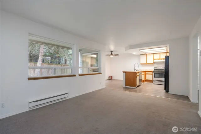 an empty room with windows and ceiling fan view