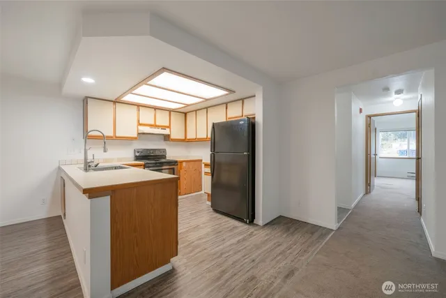 a kitchen with stainless steel appliances granite countertop a refrigerator a sink and a stove