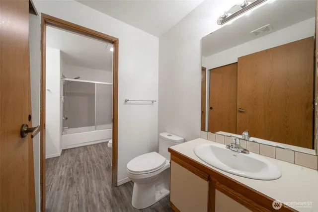 a bathroom with a sink a toilet and shower