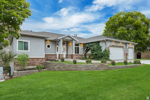 11789 Nicklaus Road Sandy, UT 84092 - Photo 52 of 58 Ranch-style house featuring brick siding, an attached garage, a front yard, and stucco siding