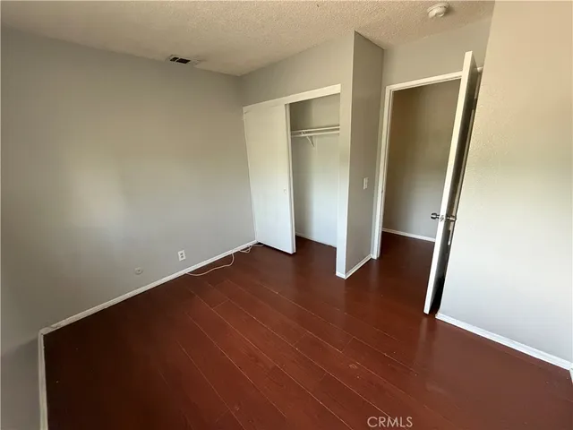 an empty room with wooden floor and closet