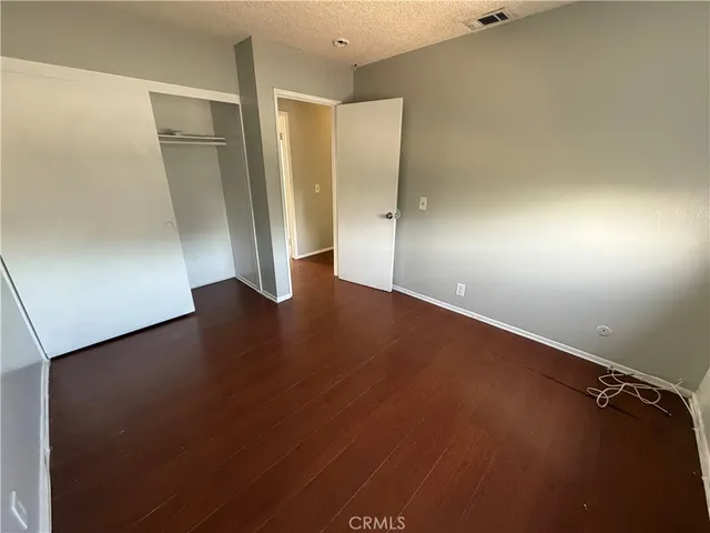 an empty room with wooden floor and closet