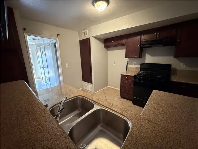 a kitchen with stainless steel appliances granite countertop a sink and a refrigerator