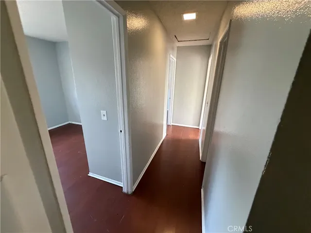 a view of a hallway with wooden floor and stairs