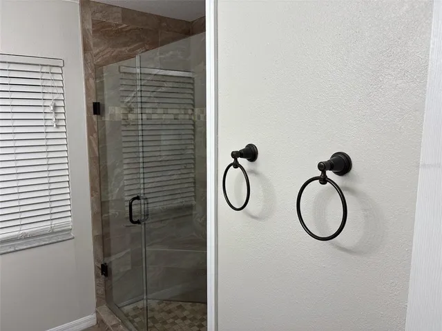 a bathroom with a granite countertop shower and a sink