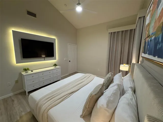 a bedroom with a bed and a flat screen tv