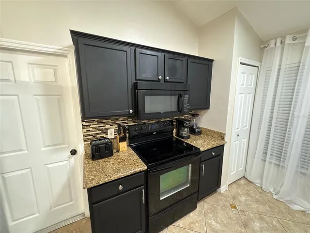 a kitchen with stainless steel appliances granite countertop a stove and a refrigerator