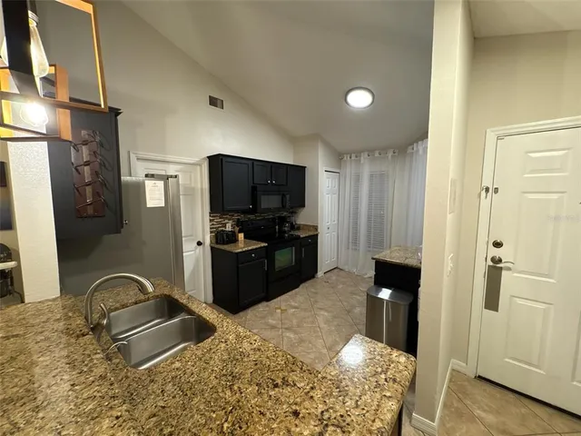 a kitchen with granite countertop a refrigerator and a sink