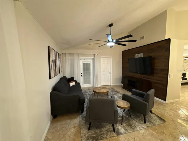 a living room with furniture a flat screen tv and a window