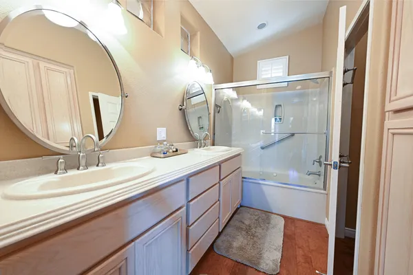 a bathroom with a double vanity sink mirror and shower