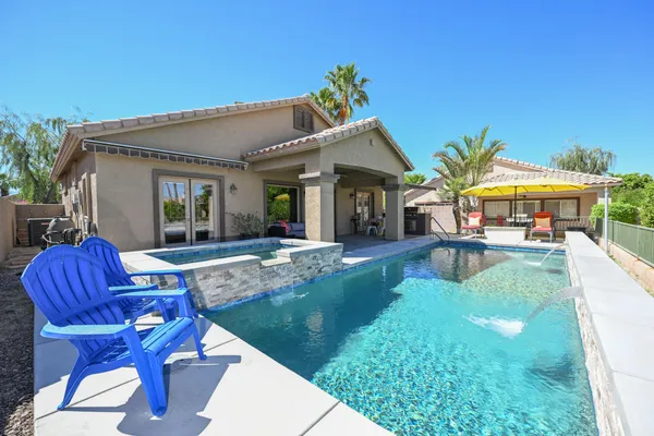 a view of a house with swimming pool and sitting area