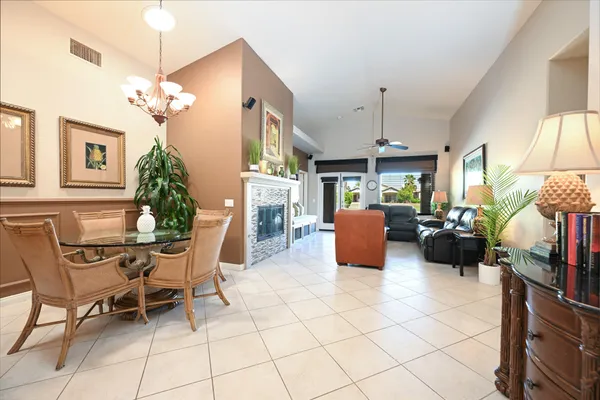 a living room with furniture a chandelier and a fireplace