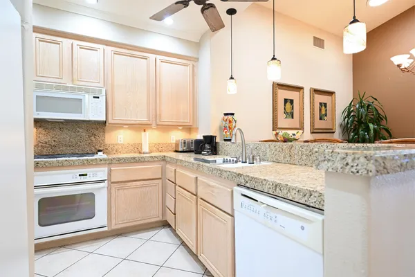 a kitchen with granite countertop white cabinets and white appliances