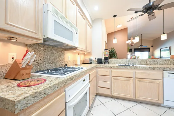 a kitchen with stainless steel appliances granite countertop a sink stove and cabinets
