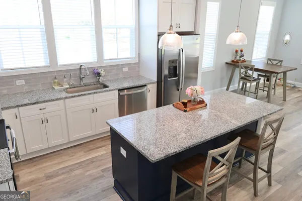 a kitchen with granite countertop kitchen island a sink counter and chairs