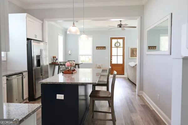 a kitchen with sink refrigerator dining table and chairs