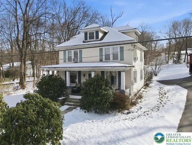 a front view of a house with a yard and tree s