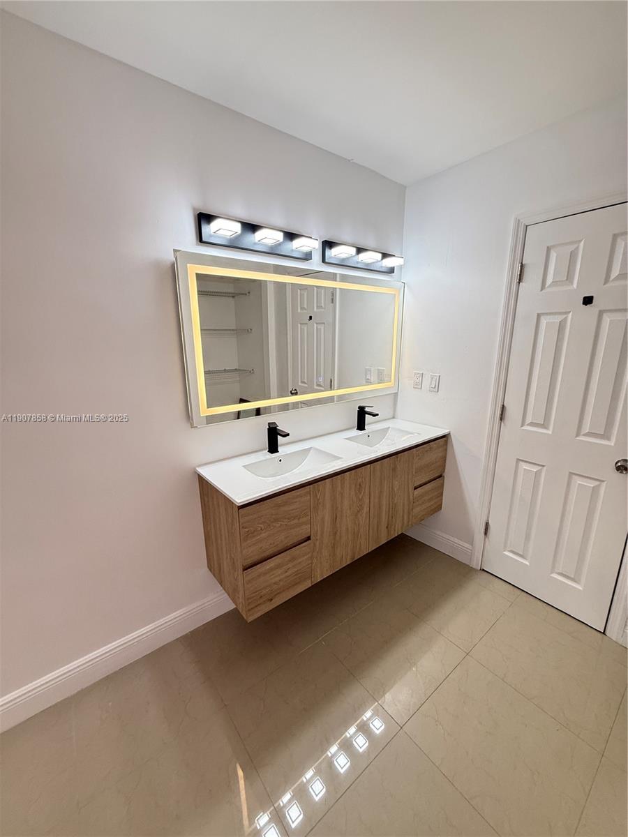 5215 Southwest 40th Avenue, Unit 48 Dania Beach, FL 33314 - Photo 11 of 12 a spacious bathroom with a tub and a sink