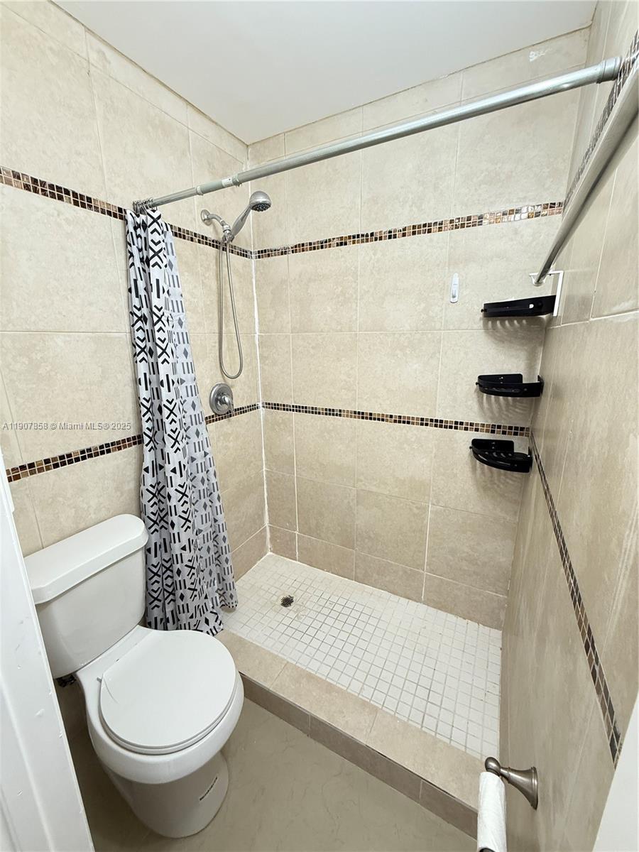 5215 Southwest 40th Avenue, Unit 48 Dania Beach, FL 33314 - Photo 12 of 12 a bathroom with a shower a toilet and a shower