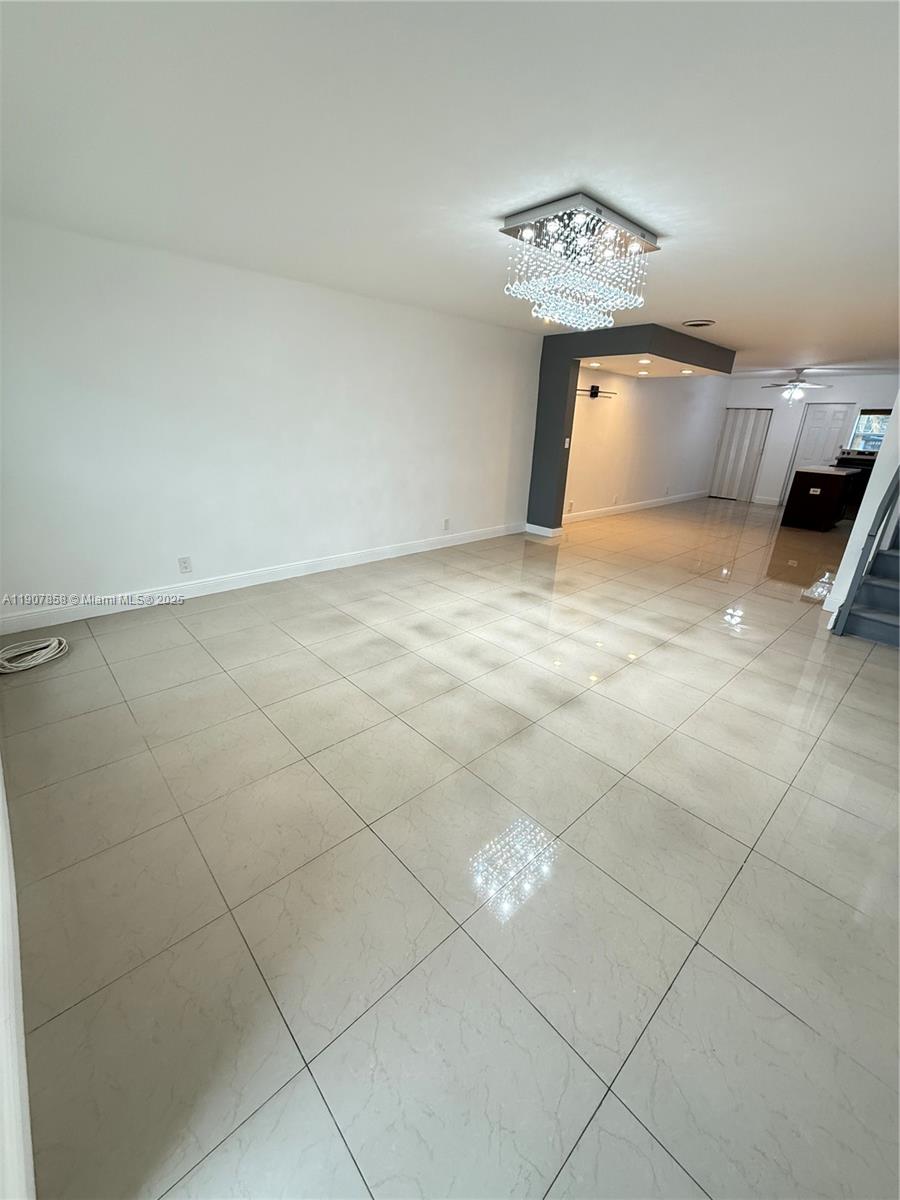 5215 Southwest 40th Avenue, Unit 48 Dania Beach, FL 33314 - Photo 2 of 12 a bedroom with a bed and a chandelier