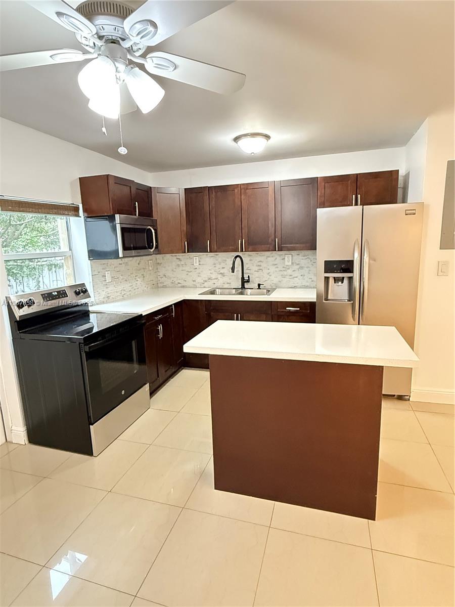 5215 Southwest 40th Avenue, Unit 48 Dania Beach, FL 33314 - Photo 4 of 12 a kitchen with stainless steel appliances a sink a counter top space cabinets and a window