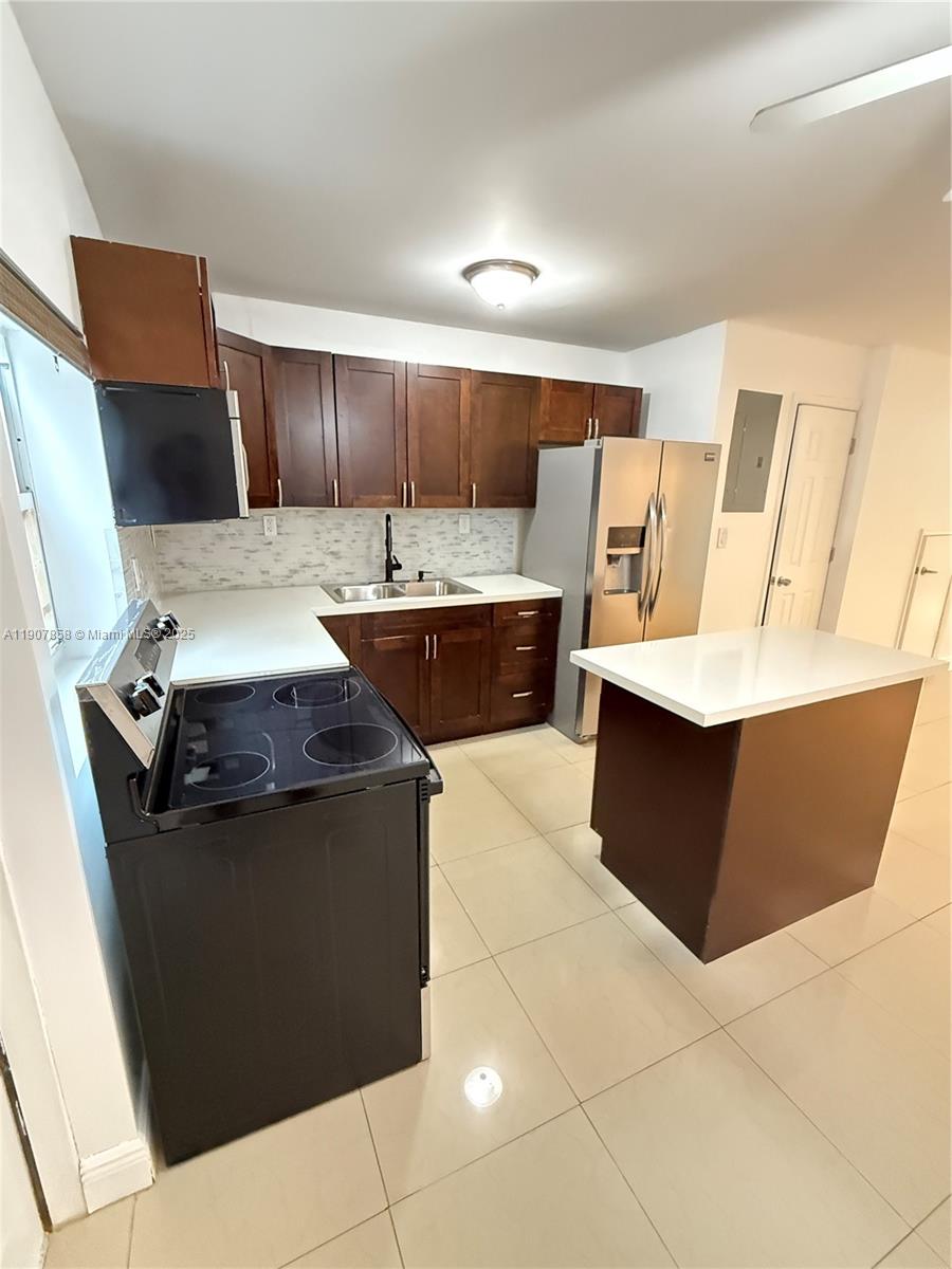 5215 Southwest 40th Avenue, Unit 48 Dania Beach, FL 33314 - Photo 5 of 12 a large kitchen with a stove a sink dishwasher and a refrigerator