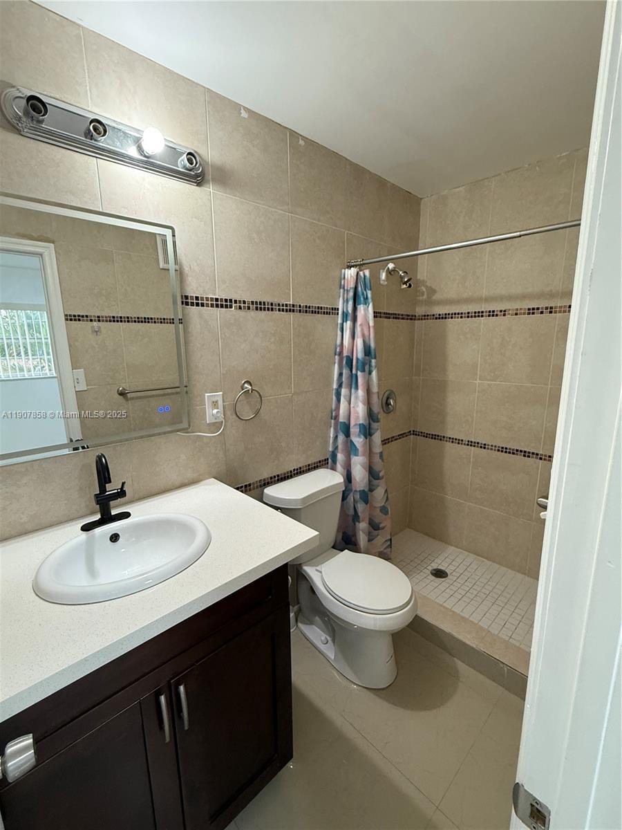 5215 Southwest 40th Avenue, Unit 48 Dania Beach, FL 33314 - Photo 9 of 12 a bathroom with a sink a toilet a mirror and shower