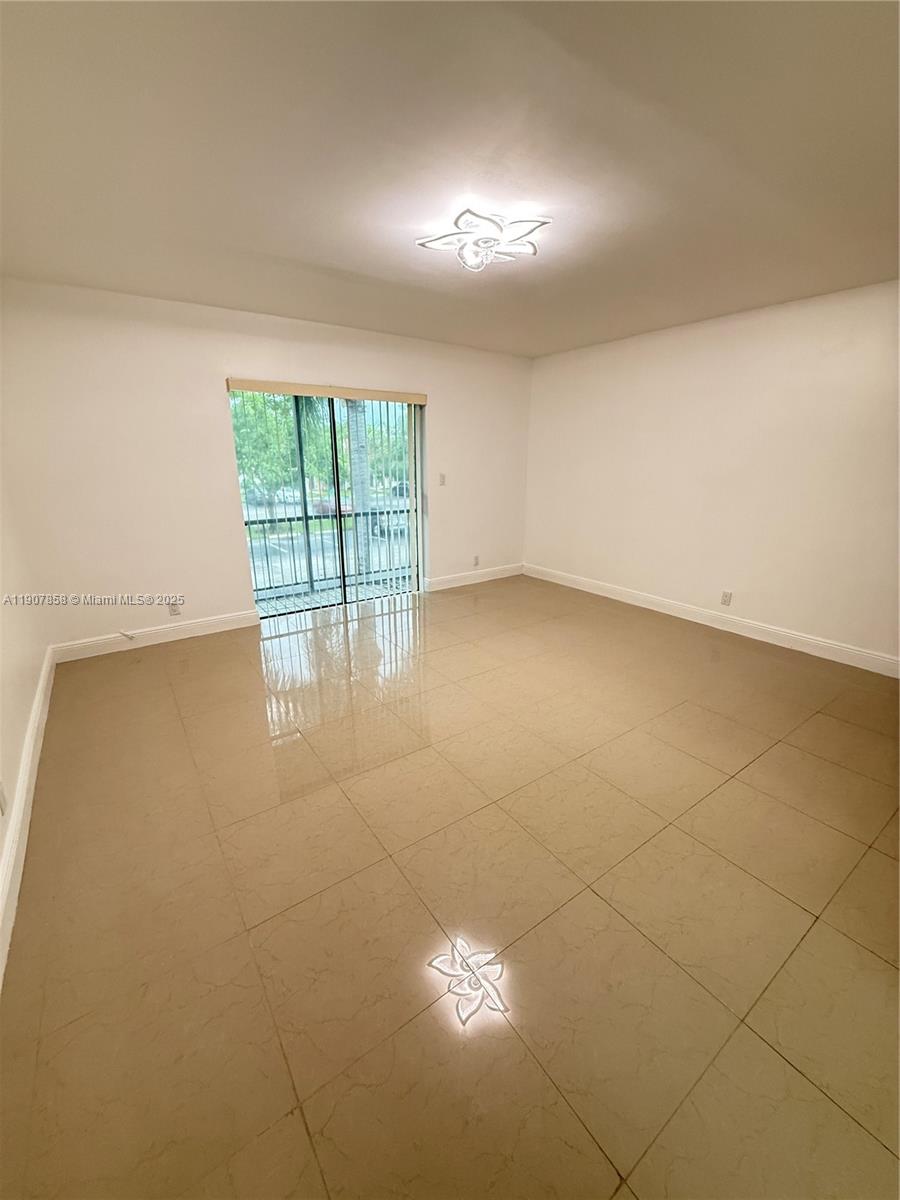 5215 Southwest 40th Avenue, Unit 48 Dania Beach, FL 33314 - Photo 10 of 12 wooden floor in an empty room with a window