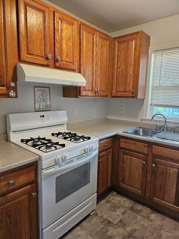 403 Manchester Street, Unit 3 Fall River, MA 02721 - Photo 4 of 15 a kitchen with granite countertop wooden cabinets and a stove top oven
