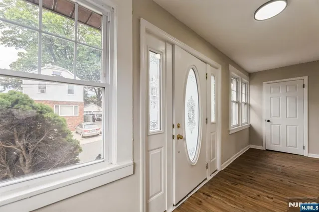 a view of hallway with furniture and wooden floor