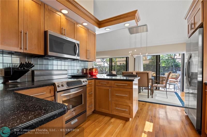 121 Landward Drive Jupiter, FL 33477 - Photo 21 of 43 a kitchen with stainless steel appliances granite countertop a stove top oven a sink dishwasher and cabinets with wooden floor