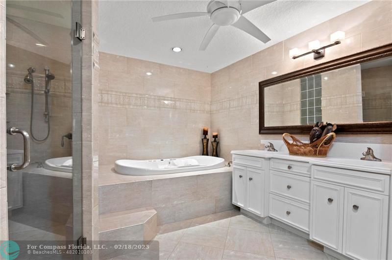 121 Landward Drive Jupiter, FL 33477 - Photo 27 of 43 a bathroom with a double vanity sink a toilet a mirror and shower