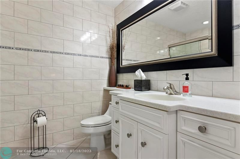 121 Landward Drive Jupiter, FL 33477 - Photo 32 of 43 a bathroom with a sink a toilet and a mirror
