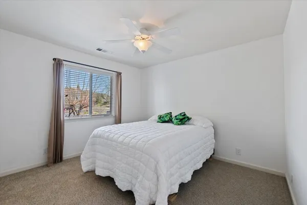 a bedroom with a bed and a chandelier fan