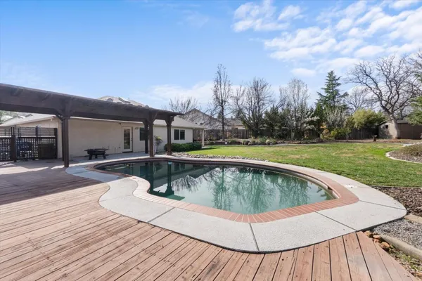 a view of a patio with table and chairs with wooden floor and fence
