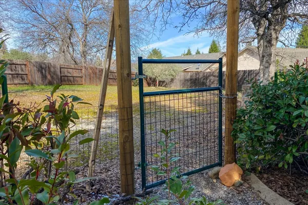 a view of a house with a yard and large trees