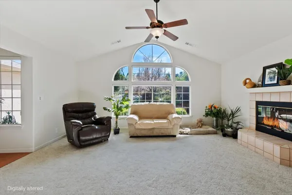 a living room with furniture chandelier and a fireplace